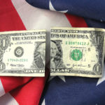 american flag with cash linking patriotism with finiancial interests